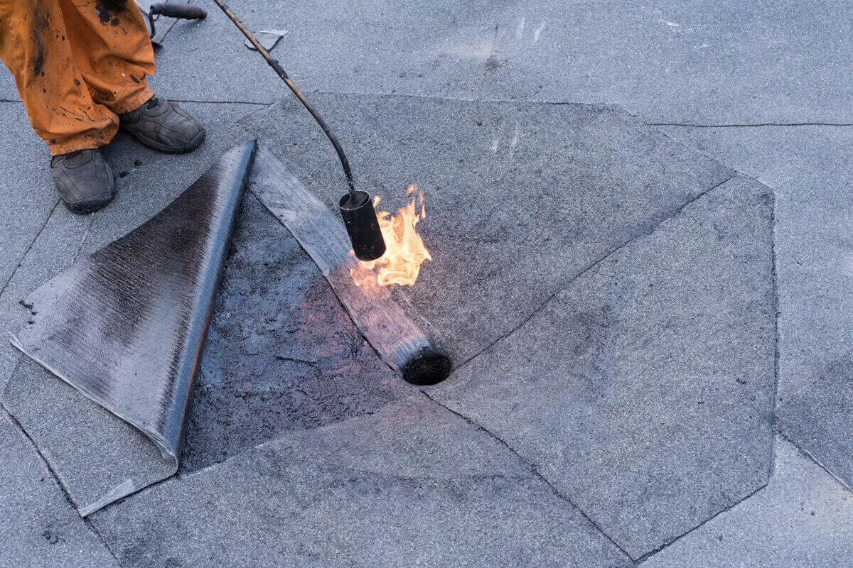 Roofer repairing drain.