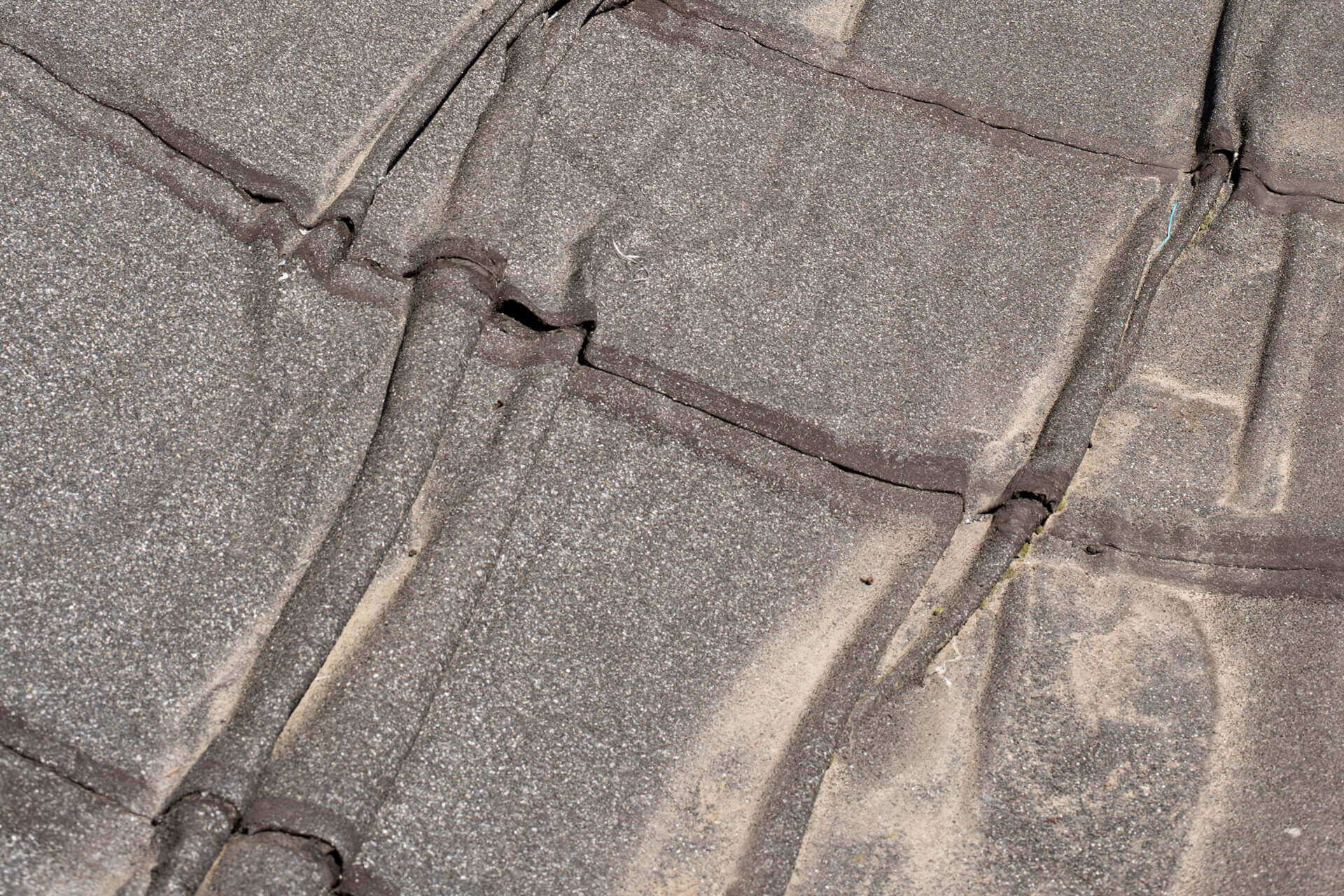 Wrinkled roofing felt.